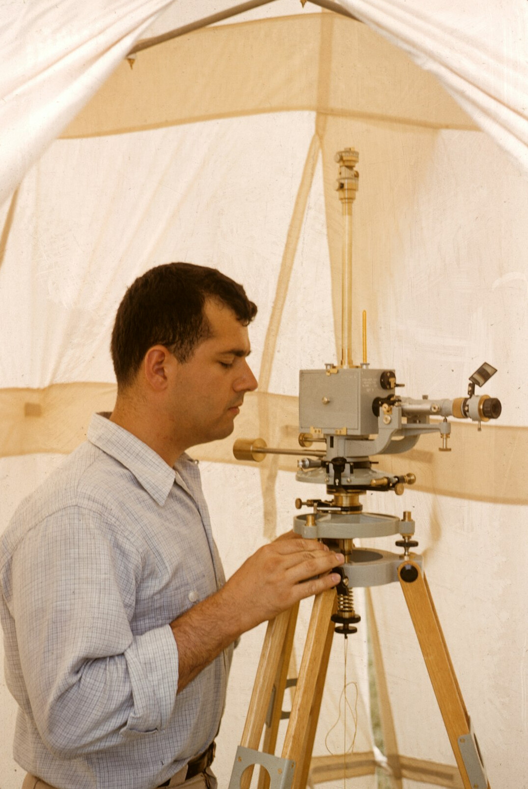 Camera operator adjusting a broadcast camera on a studio pedestal